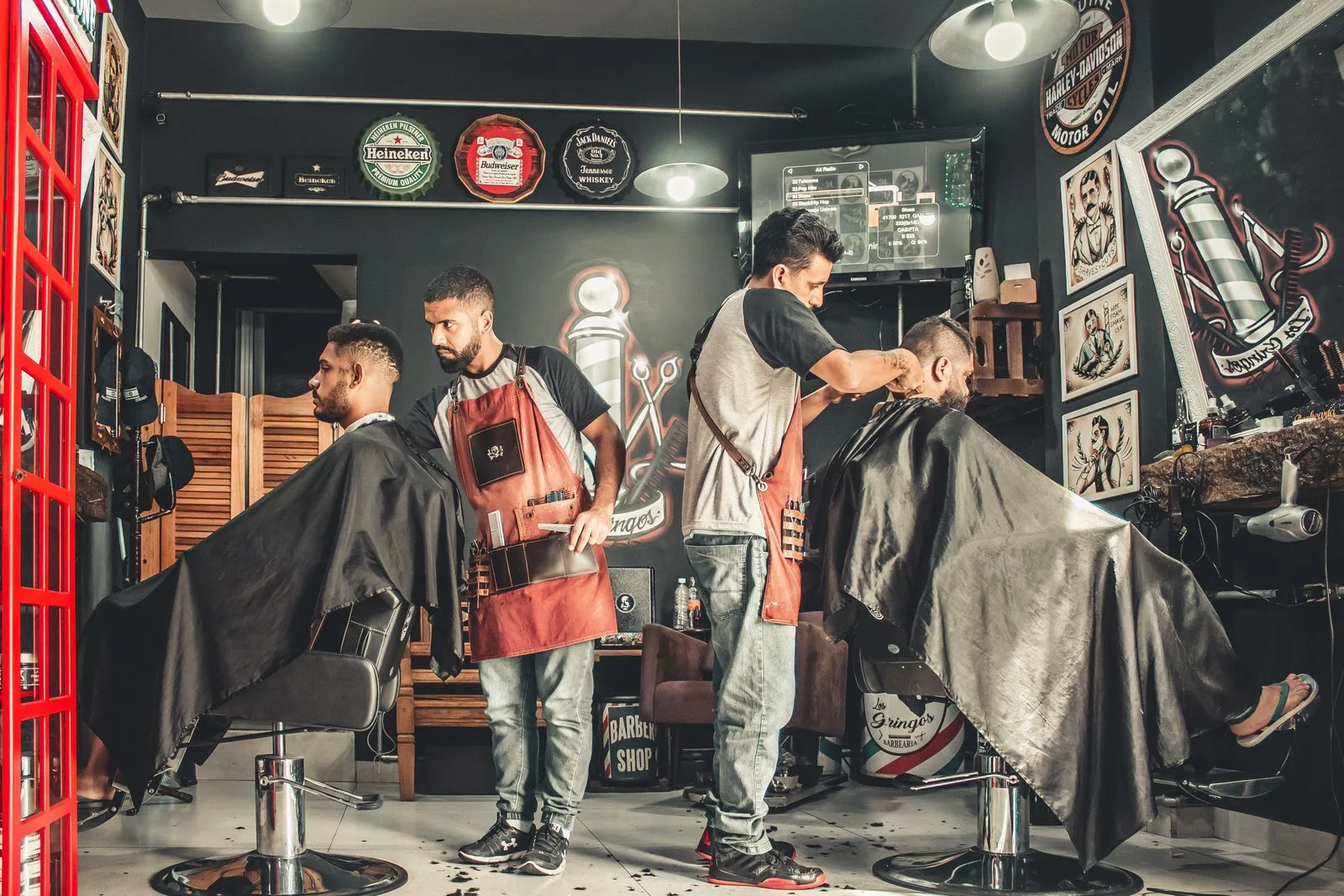 Barberos atendiendo clientes dentro de un negocio local